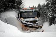 A truck with a snowplow clears the road for the last snowfall.